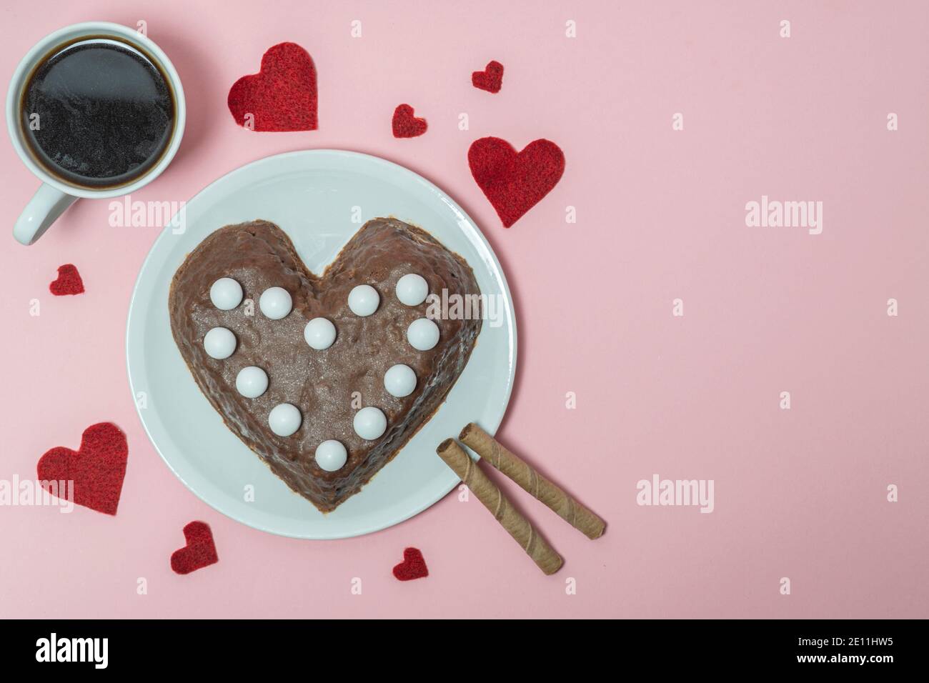 Schokoladenkuchen in Herzform auf rosa Hintergrund. Konzept zum Valentinstag. Hohe Qualität Stockfoto