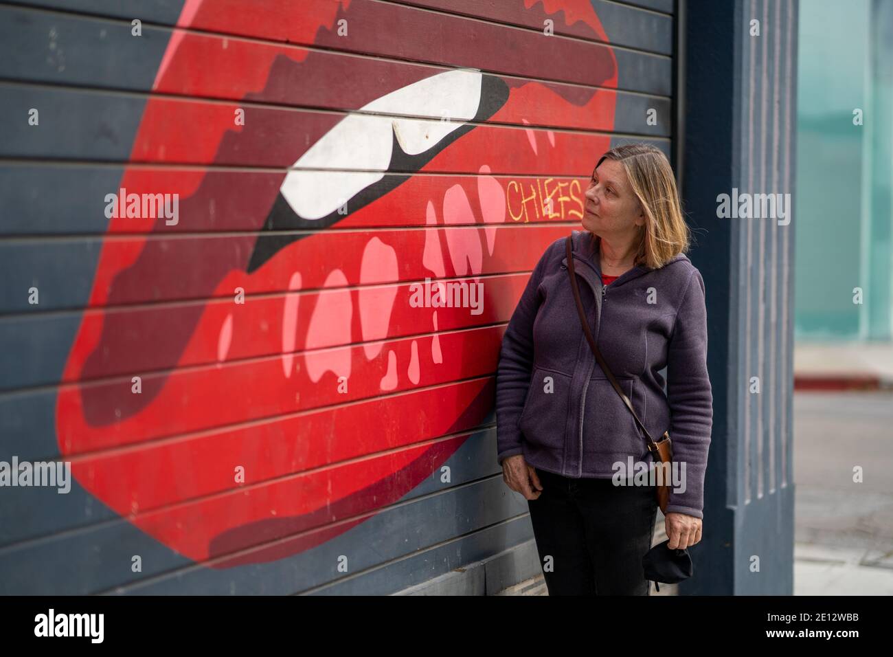 Frau mittleren Alters bewundert Street Art / Graffiti Stockfoto