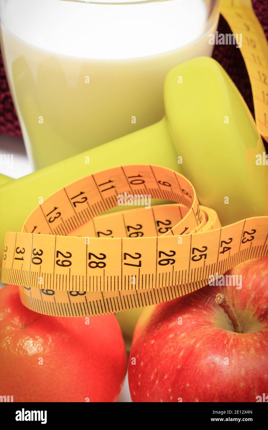 Maßband, frische reife Früchte und Kurzhanteln mit in Fitness. Abnehmen, gesunde Ernährung und sportliche Lebensstile Stockfoto