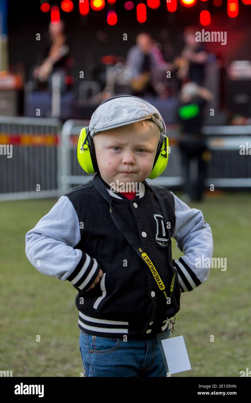 Kleiner Junge mit Gehörschutz bei einem Rockkonzert. Stockfoto
