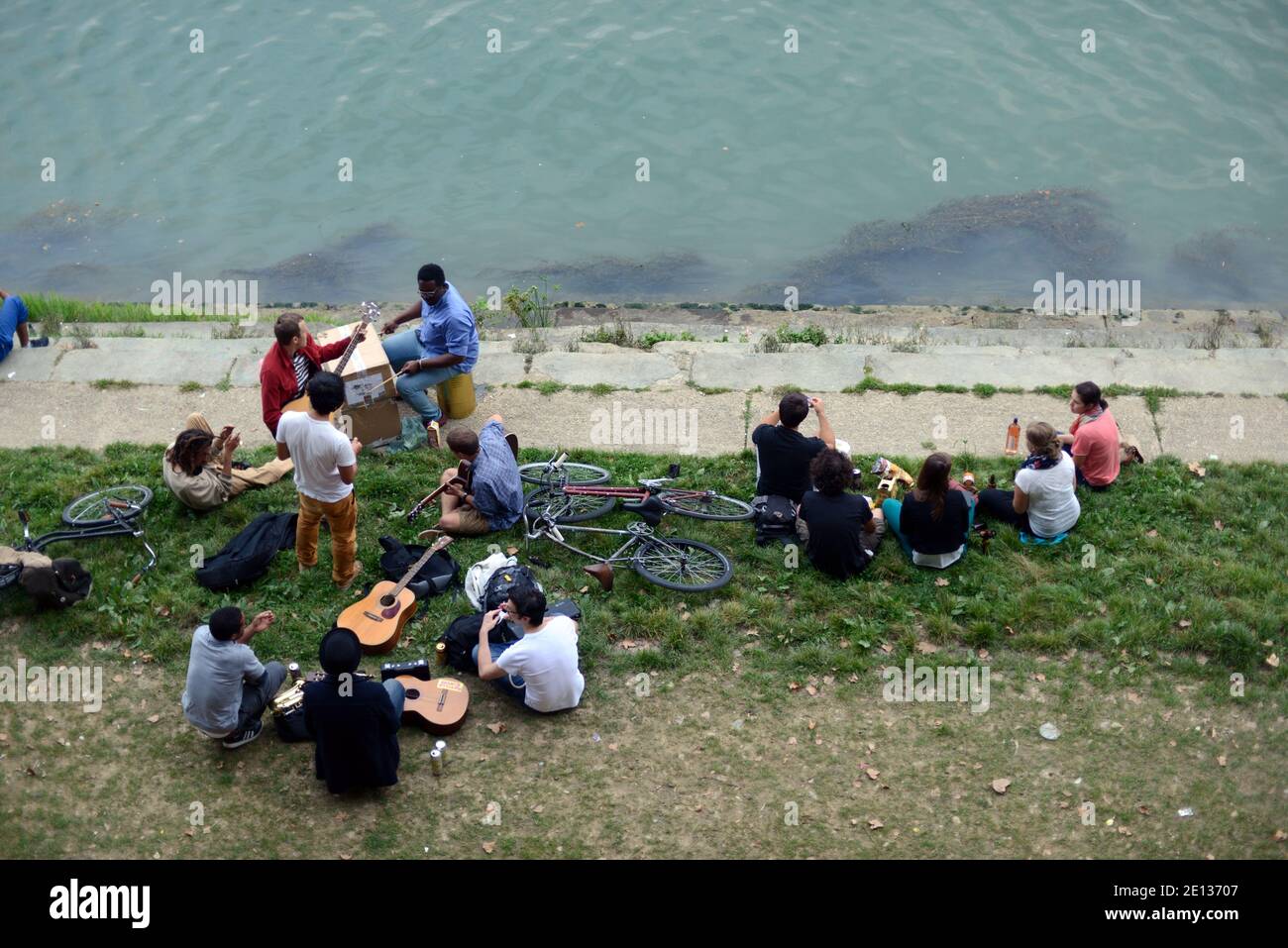 Studenten oder Jugendliche picknicken und Musik spielen auf dem Ufer der Garonne Toulouse Frankreich Stockfoto