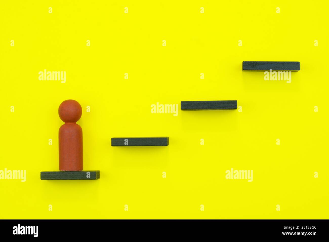Führungs- und Karrierekonzept. Holzfigur, die die Stufen hinauf klettert Stockfoto
