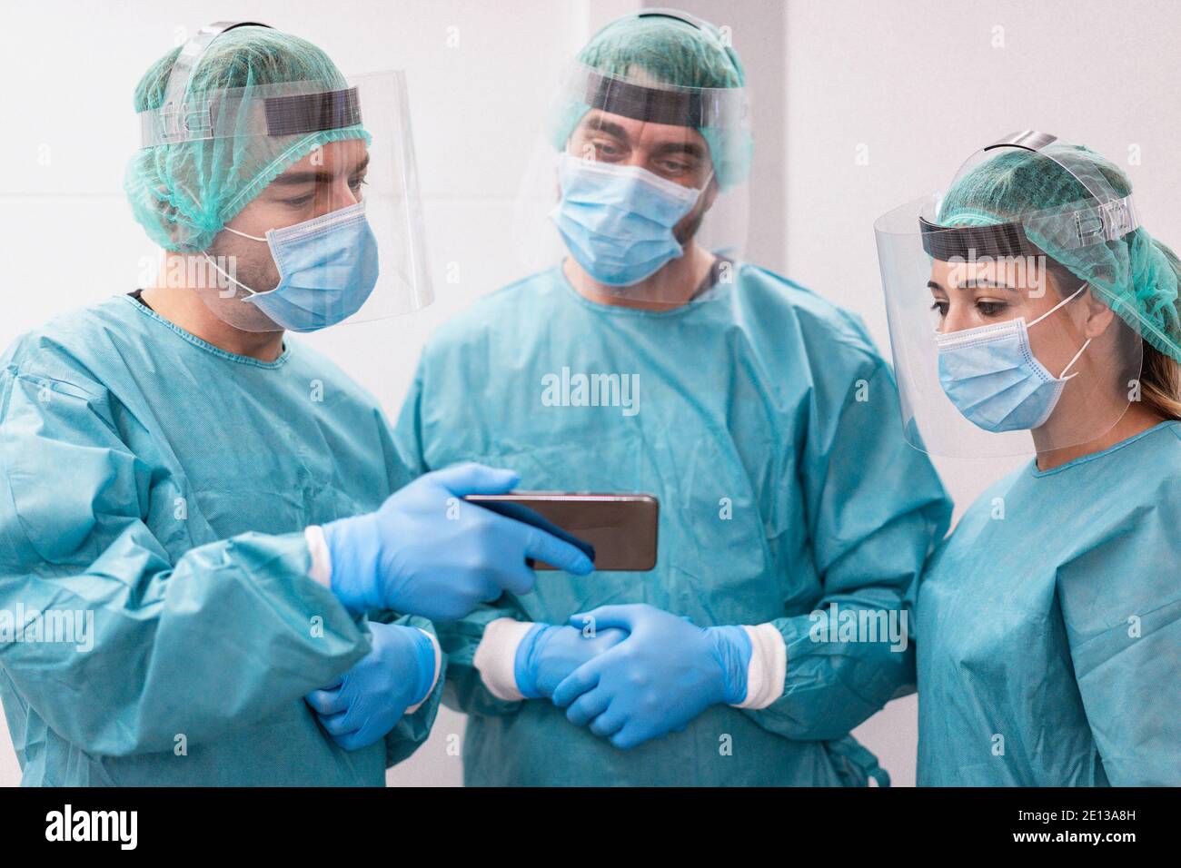 Medizinische Arbeit Team suchen Ansteckung Spitze mit Handy in Krankenhauszimmer - Fokus auf die richtige Frau Stockfoto
