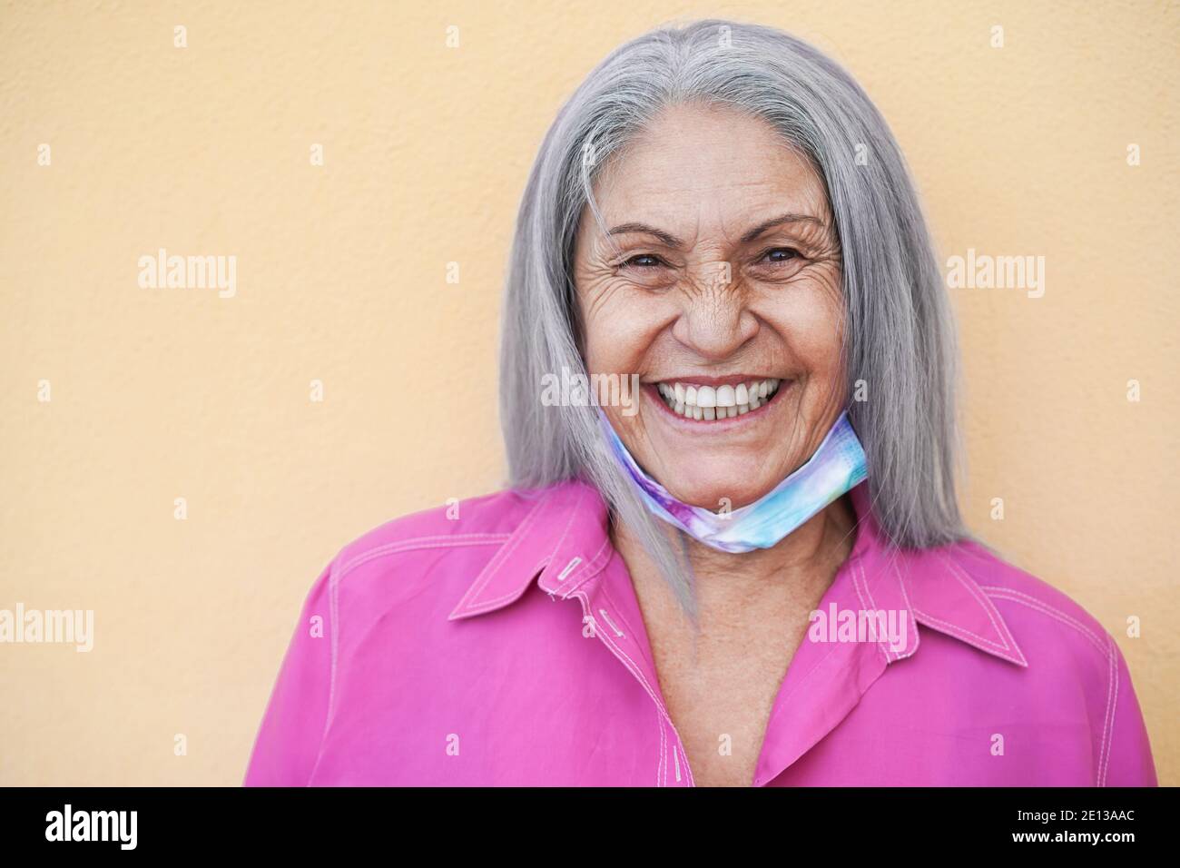 Ältere Frau mit Schutzmaske unter dem Kinn während des Coronavirus-Ausbruchs - Fokus auf Gesicht Stockfoto