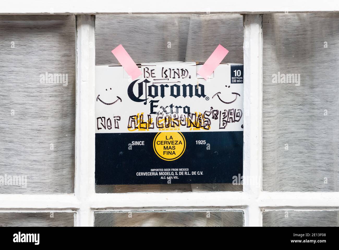 Gesehen in Presteigne, Mitte Wales, Großbritannien, während der ersten Covid-Sperre - ein Schild in einem Fenster, das auf einem Pack Corona-Bier stand und sagte: „Seid freundlich - nicht alle Coronas sind schlecht“ (UK) Stockfoto