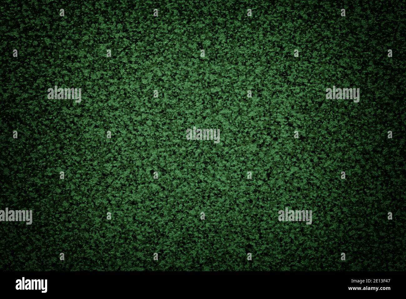 Körniger grüner Hintergrund der Tischplatte mit dunkler Vignette. Textur abstrakte Oberfläche mit kleinen Krümelmuster für Innenarchitektur und Küchenarbeitspläche. Stockfoto