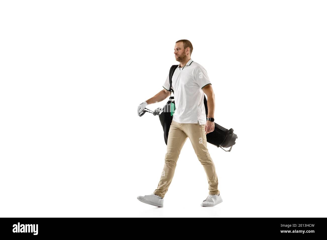 Los. Golfspieler in einem weißen Hemd üben, spielen isoliert auf weißem Studio-Hintergrund mit Copyspace. Professionelle Spieler üben mit hellen Emotionen und Gesichtsausdruck. Sportkonzept. Stockfoto