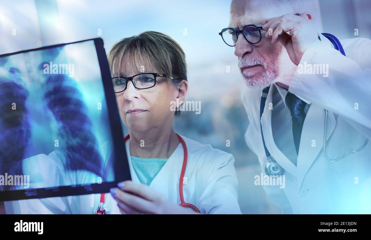 Zwei Ärzte untersuchen Röntgenbericht in der Arztpraxis; Lichteffekt Stockfoto