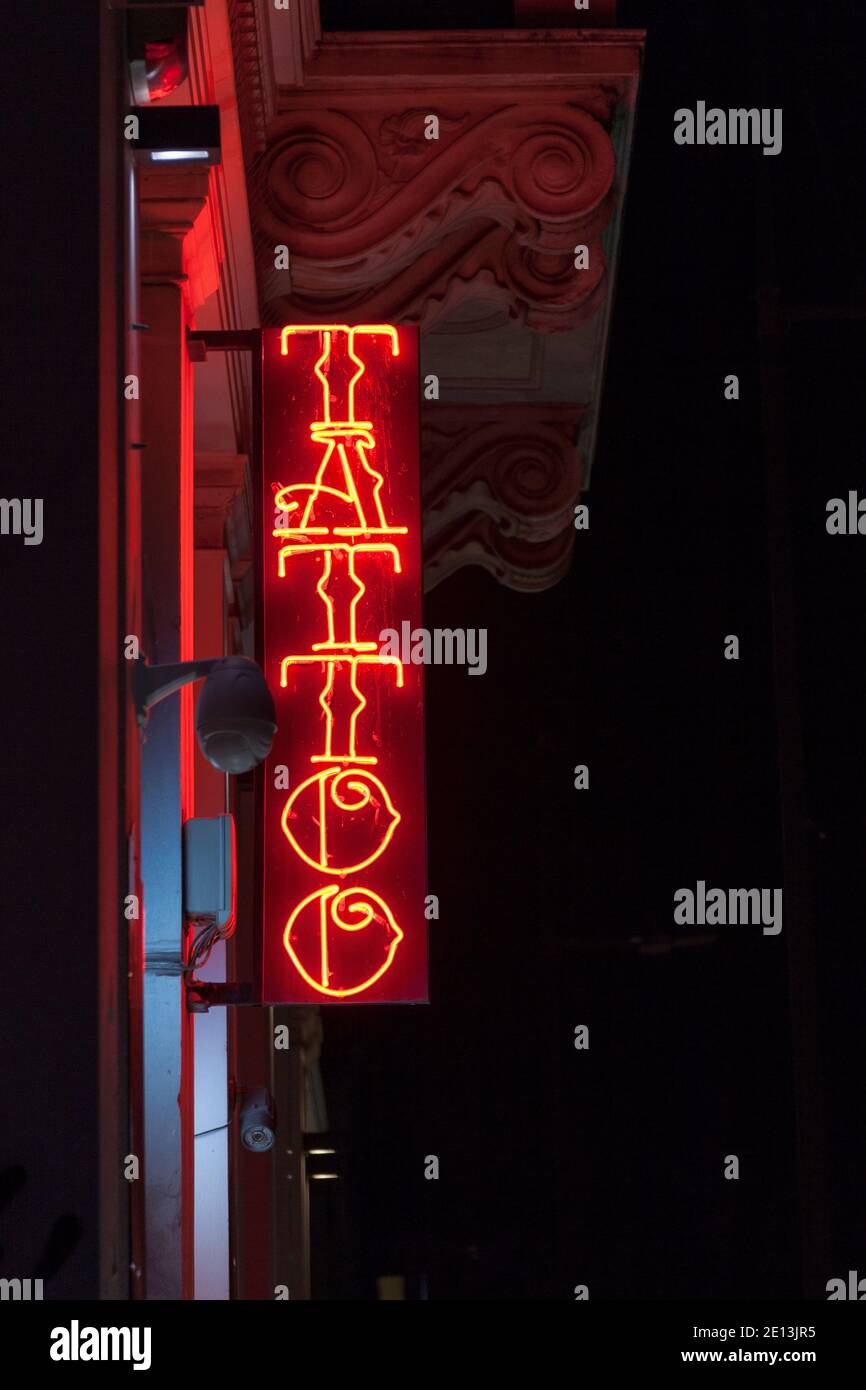 Nahaufnahme eines roten Neonlichts in Form des Wortes „Tattoo“. Stockfoto
