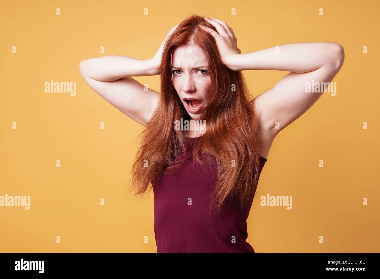 Frustriert wütend junge Frau hält ihren Kopf schreiend Stockfoto