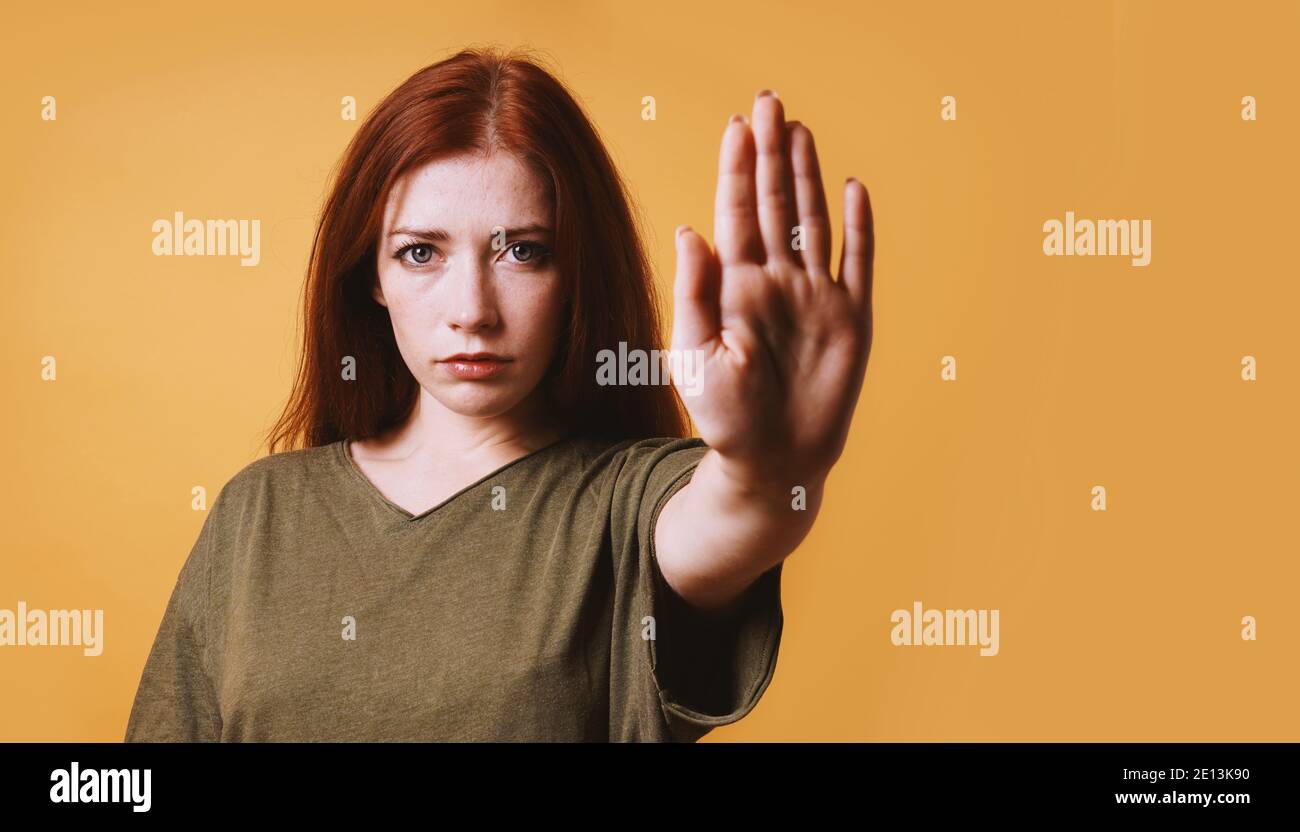 Seriöse junge Frau macht Stopp oder Halt Geste mit ihr Linke Hand Stockfoto