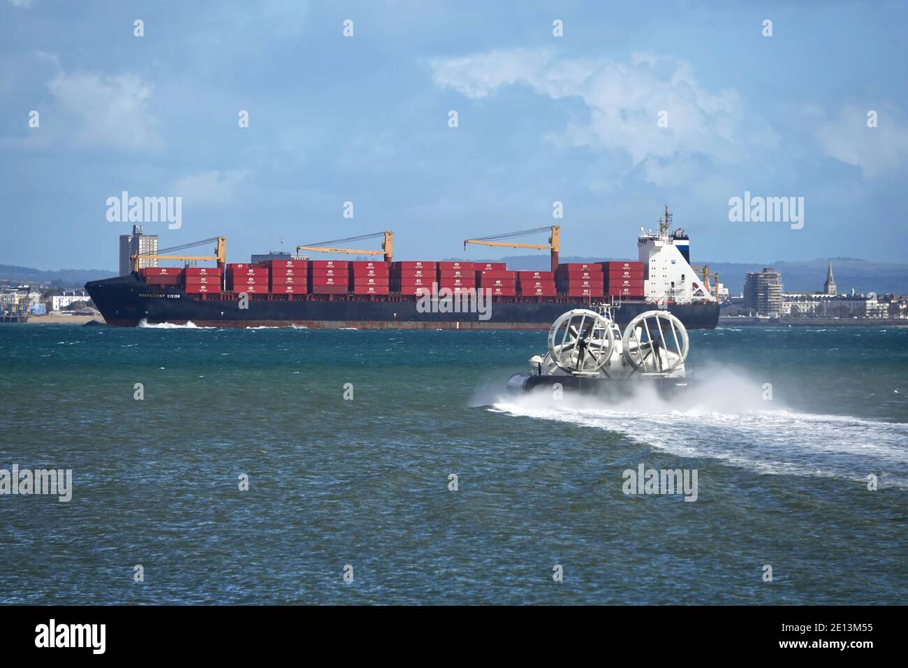 Das Hovercraft Solent Flyer überquert die Solent nach Portsmouth von Ryde auf der Isle of Wight mit dem Containerschiff Independent Vision vor ihm. Stockfoto