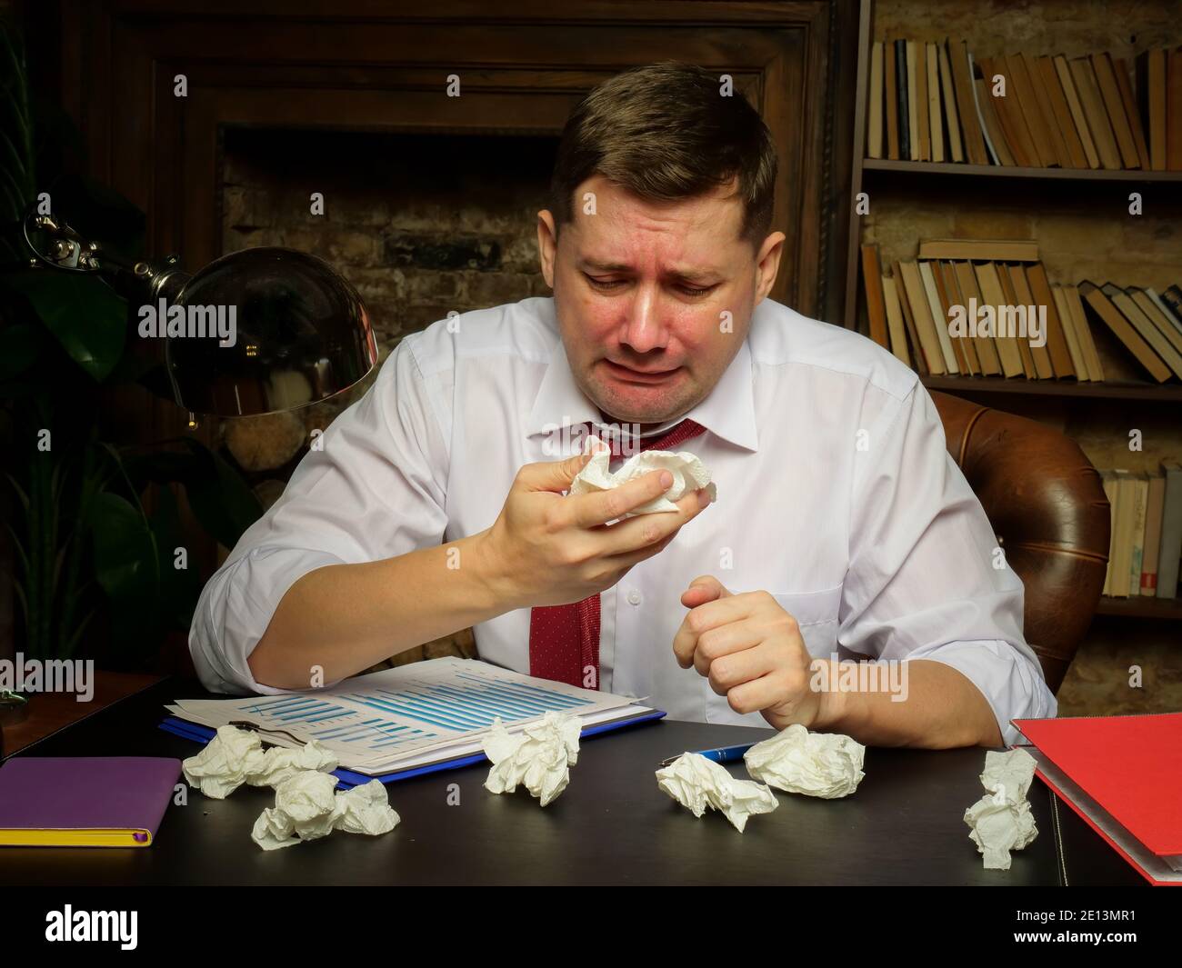 Kranker Arbeiter mit kalter und laufender Nase am Arbeitsplatz. Stockfoto