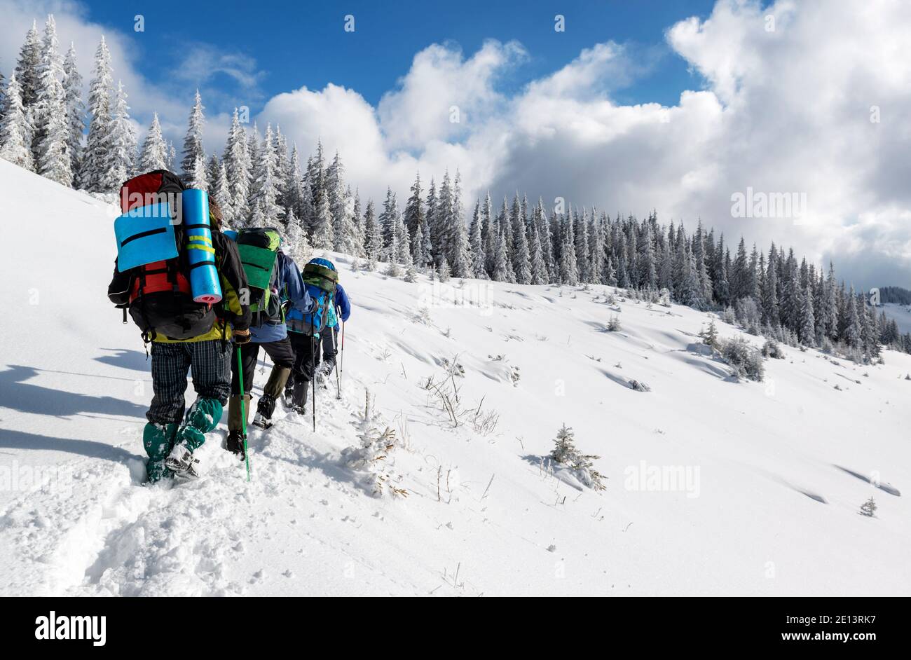 Wanderer mit Rucksäcken Klettern in den Winterbergen während einer Helle sonnige Tage Stockfoto