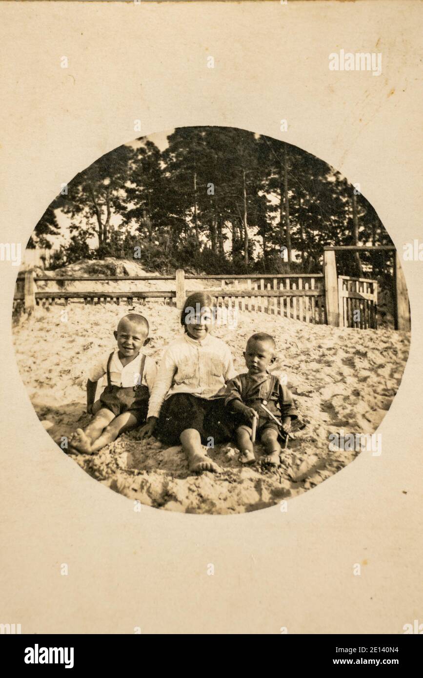 Deutschland - CA. 1920er Jahre: Gruppenfoto von Baumkids, die im Garten auf dem Boden sitzen. Vintage Archiv Art Deco Ära Fotografie Stockfoto