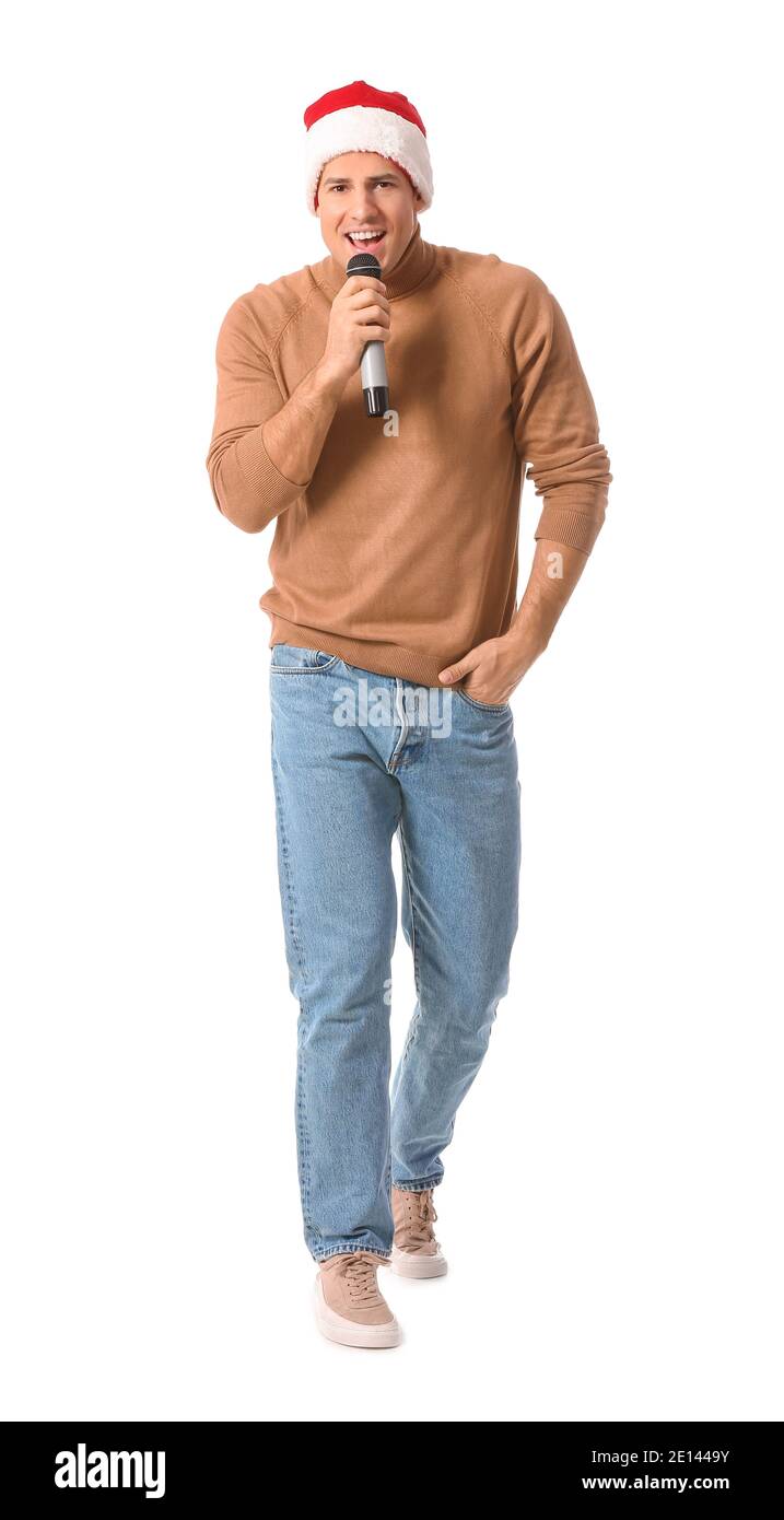 Junger Mann mit Mikrofon singt Weihnachtslied auf weißem Hintergrund Stockfoto Junger Mann mit Mikrofon singt Weihnachtslied auf weißem Hintergrund Stockfoto