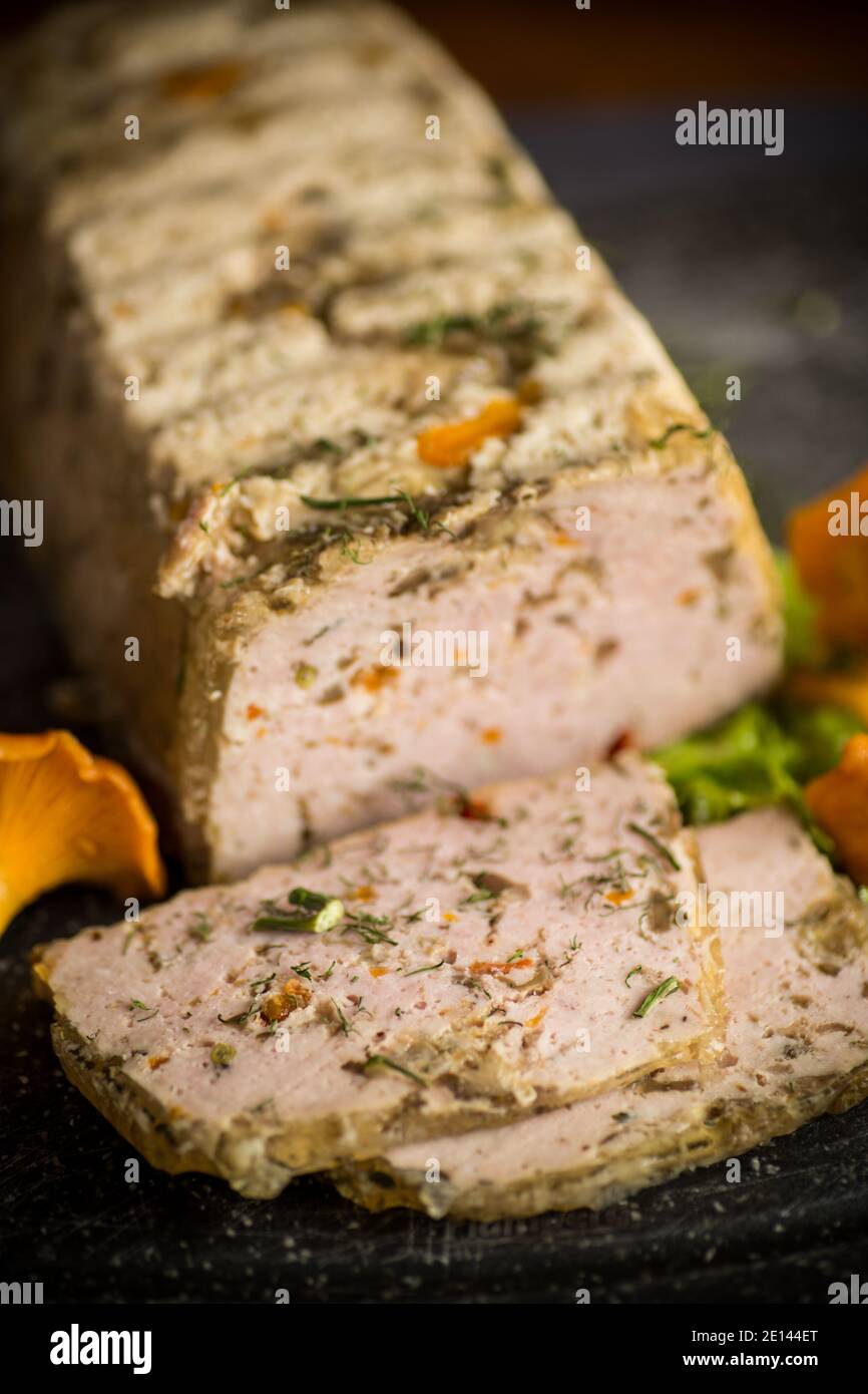 Hausgemachte Wurst aus Hackfleisch mit Pilzen und Gemüse im Inneren, auf einem Holztisch Stockfoto