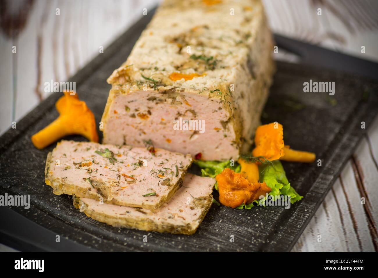Hausgemachte Wurst aus Hackfleisch mit Pilzen und Gemüse im Inneren, auf einem Holztisch Stockfoto