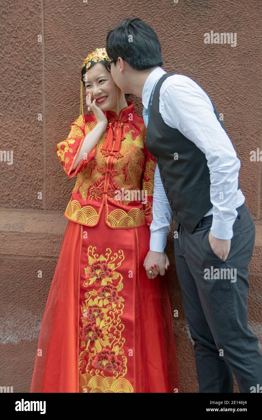 Bei einem Fotoshooting vor der Hochzeit lässt ein Bräutigam seine traditionell gekleidete Braut lächeln. In Greenwich Village, Manhattan, New York City. Stockfoto