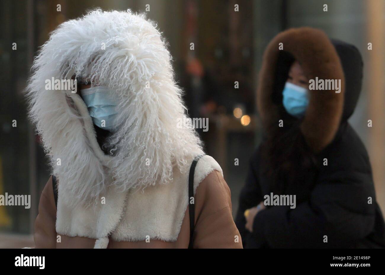 Peking, China. Januar 2021. Chinesen tragen Gesichtsmasken, während sie am Montag, den 4. Januar 2021, eine normalerweise geschäftige Einkaufsstraße in Peking besuchen. Chinas Hauptstadt hat in der letzten Woche neue Covid-19-Fälle registriert, was die lokalen Behörden dazu veranlasste, einen "Notstand" auszurufen. Foto von Stephen Shaver/UPI Kredit: UPI/Alamy Live Nachrichten Stockfoto