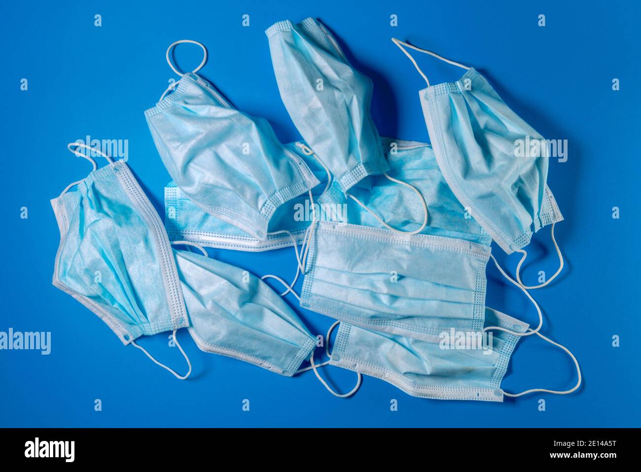 Chirurgische Gesichtsmasken auf blauem Hintergrund verwendet. Medizinische Masken für Covid-19 Schutz - ökologisches Recyclingkonzept Stockfoto