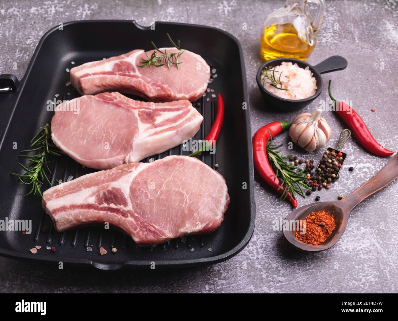 Frische rohe Stücke Fleisch Schweinefleisch, Rindfleisch, hacken auf einem Knochen, auf Grillpfanne, Gewürze Stockfoto