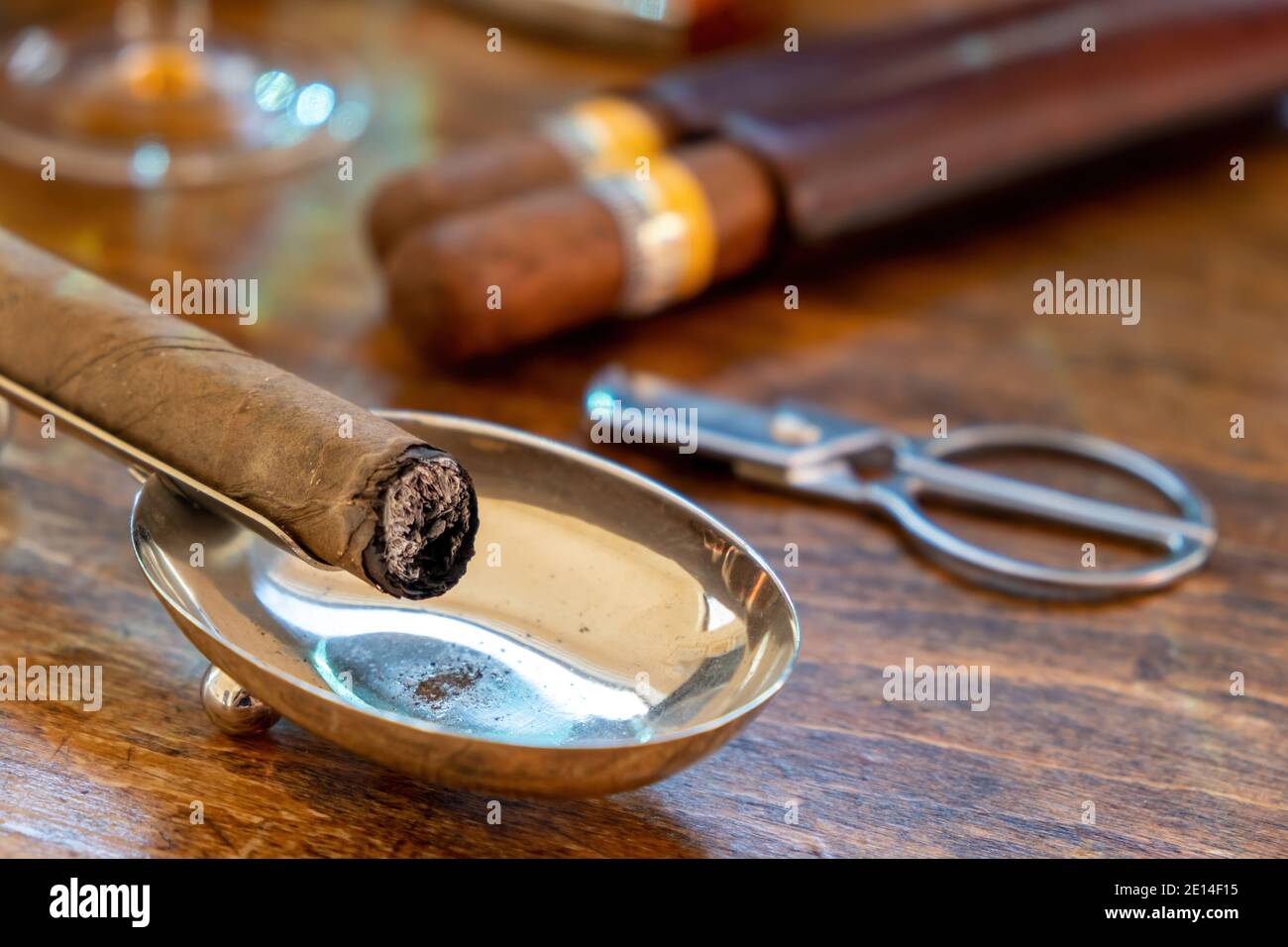 Zigarre in einem Aschenbecher, Holztisch, Nahaufnahme. Kubanische Qualität Zigarre verbrannt, Rauchen Luxus Lebensstil Stockfoto