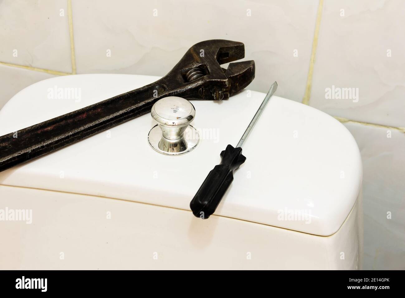 Zisterne für die Spülung von Wasser auf der Toilette und ein Satz von Werkzeugen für die Reparatur der Zisterne. Stockfoto