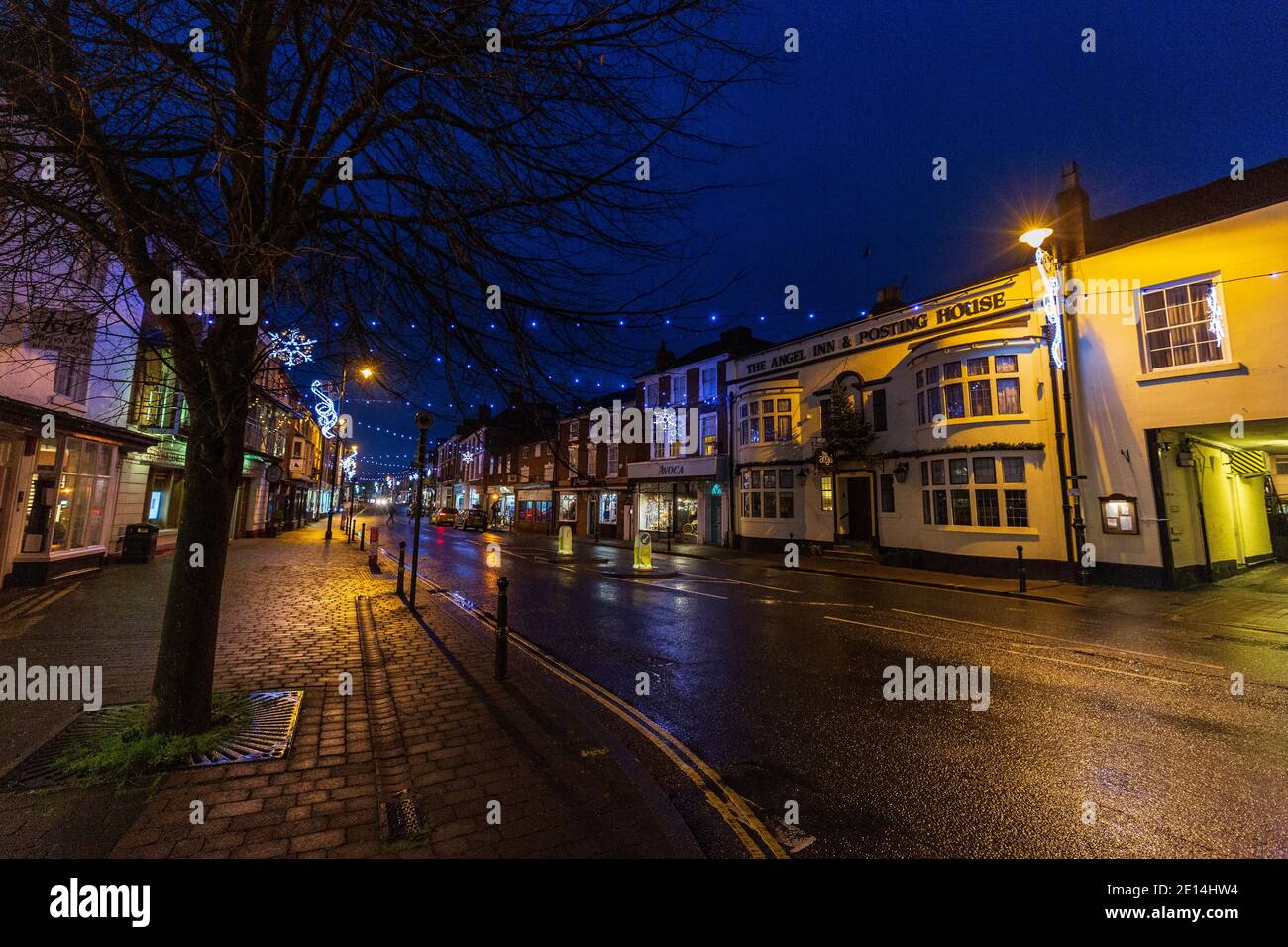 Pershore High Street nach Einbruch der Dunkelheit mit Weihnachtsschmuck, Worcestershire, England Stockfoto