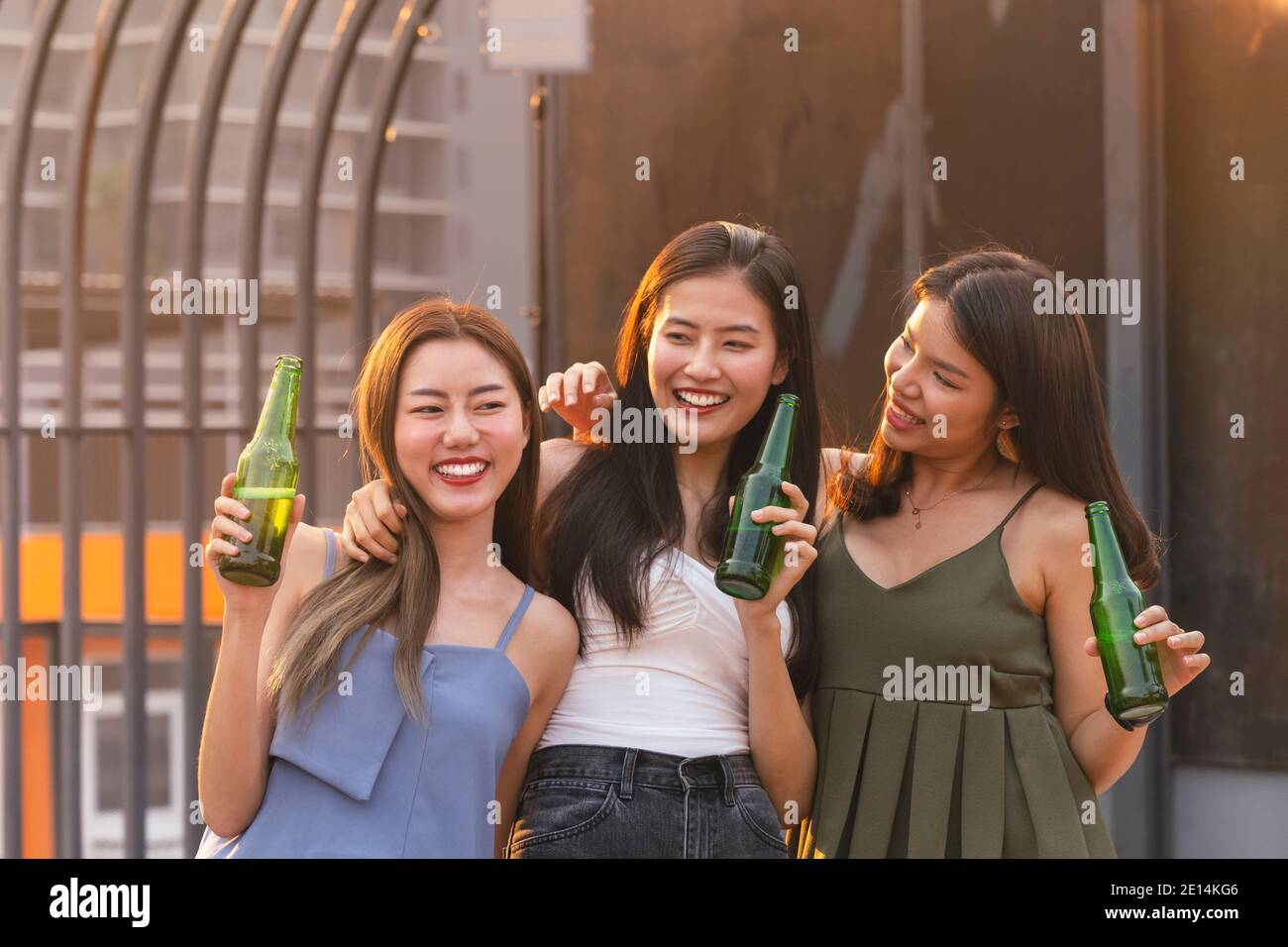asiatische Frau Jugendliche jubeln und Toast mit Bierflasche zu feiern beim Abendessen Party im Sommer. Feier, Beziehung und Freundschaft conce Stockfoto