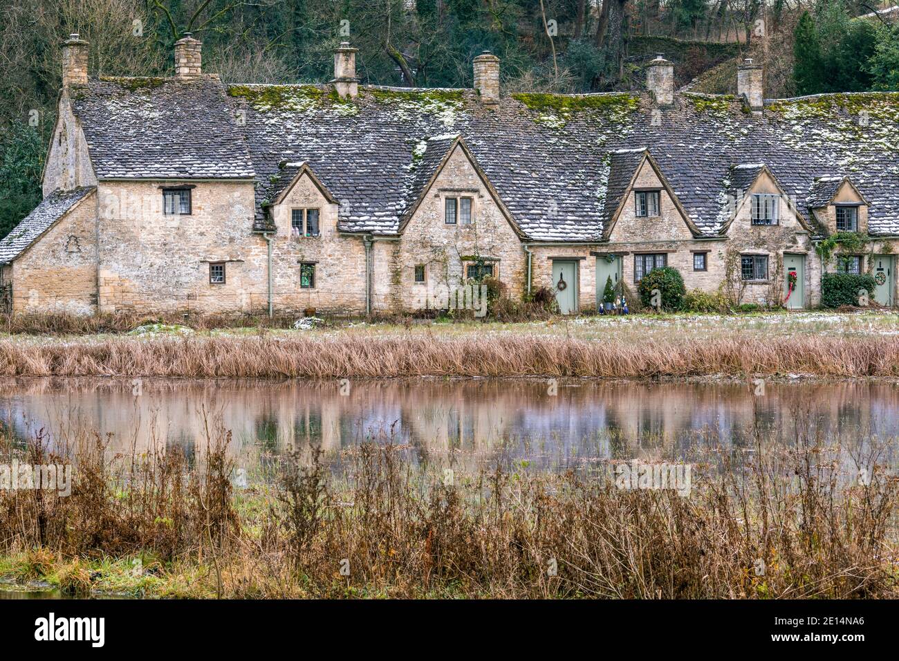 Spiegelung der Arlington Row im Dezember 2020 im Cotswold-Dorf Bibury, Gloucestershire, Großbritannien, im Flutwasser des Flusses Coln auf Rack Isle Stockfoto