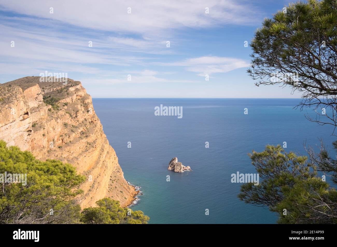 Felsenküste und smaragdgrünes Meer mit winziger Insel in der Nähe von Sierra Helada Naturpark Stockfoto
