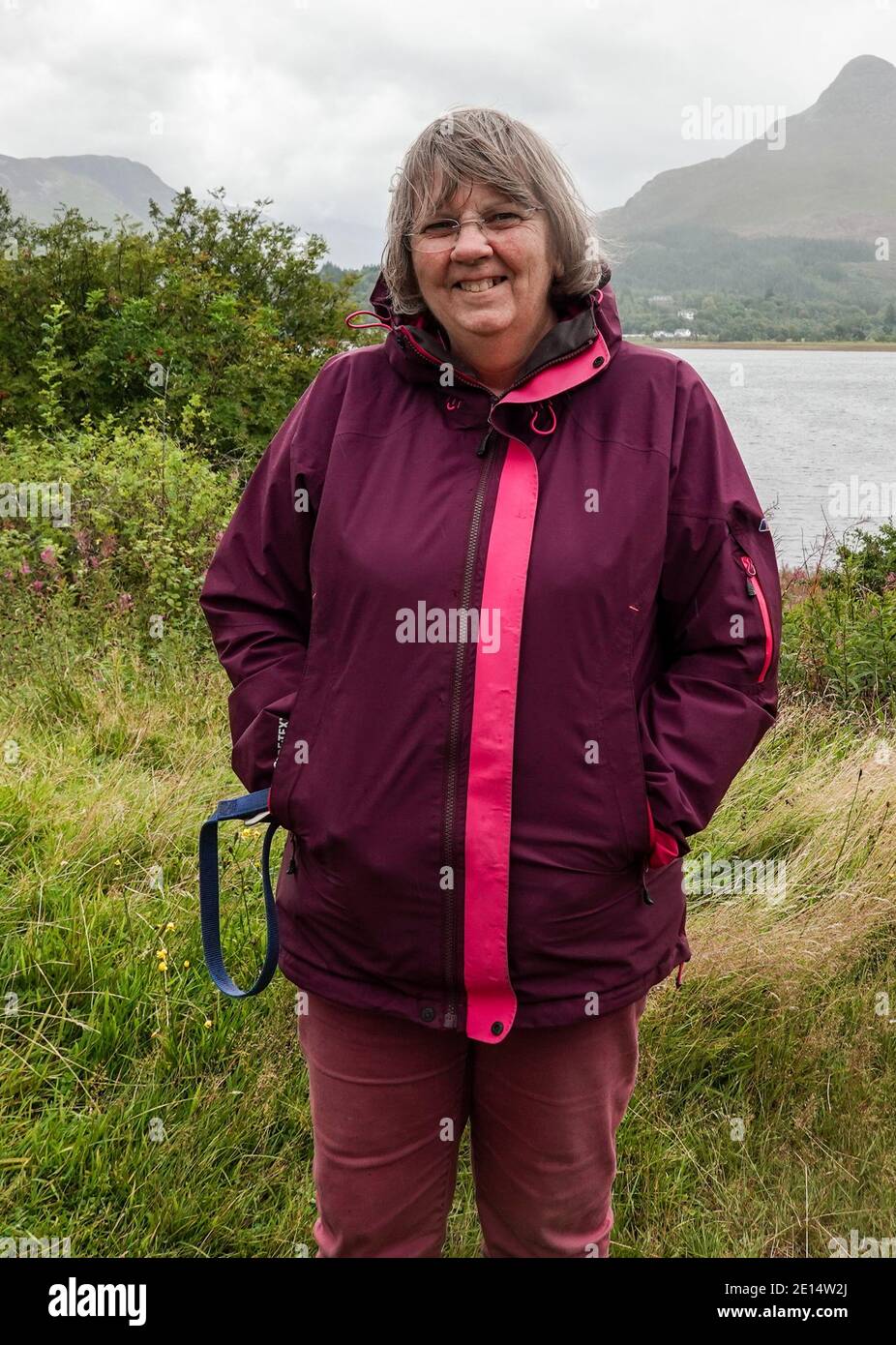 Frau in den Sechzigern, die in Ballachulish, neben Loch Leven, Highland, steht Stockfoto