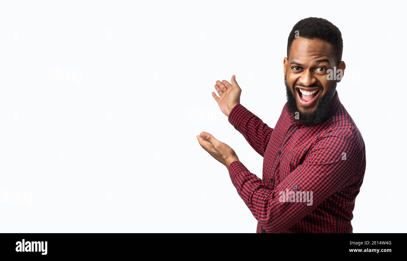 Aufgeregt African Guy Gesturing Zeigt Copy Space Beiseite, Weißer Hintergrund Stockfoto