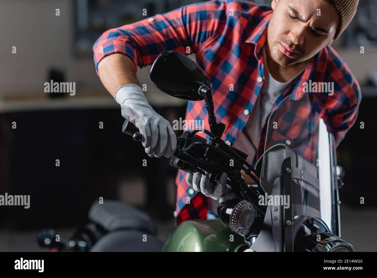 Junger Mechaniker überprüft Bremsgriff auf Motorrad-Lenker Stockfoto