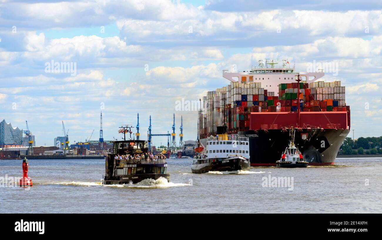 Moderne Hafenfähre, historischer Dampfeisbrecher und mächtiges Containerschiff mit Schlepper auf der Elbe bei Hamburg Stockfoto