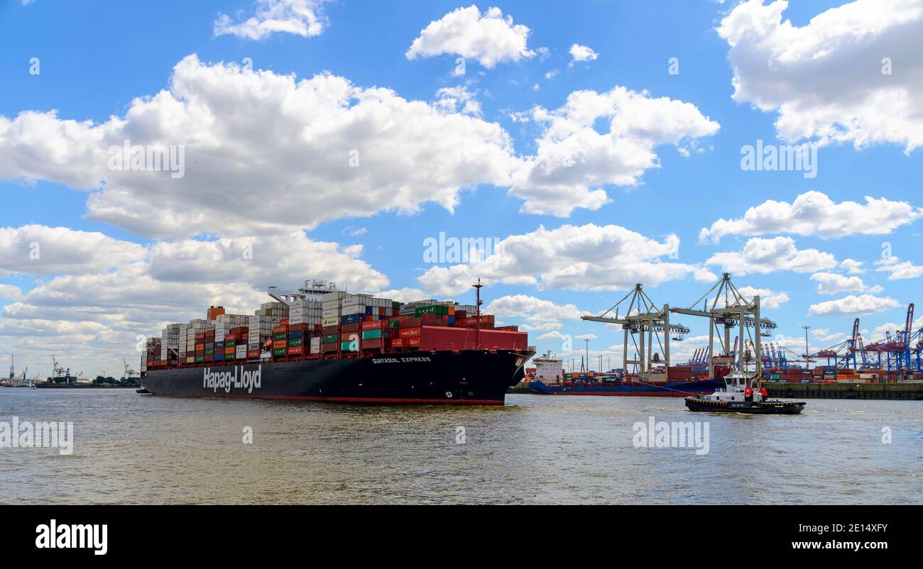 Mächtiges Containerschiff im Schlepptau eines Hafenschleppers auf der Elbe bei Hamburg Stockfoto