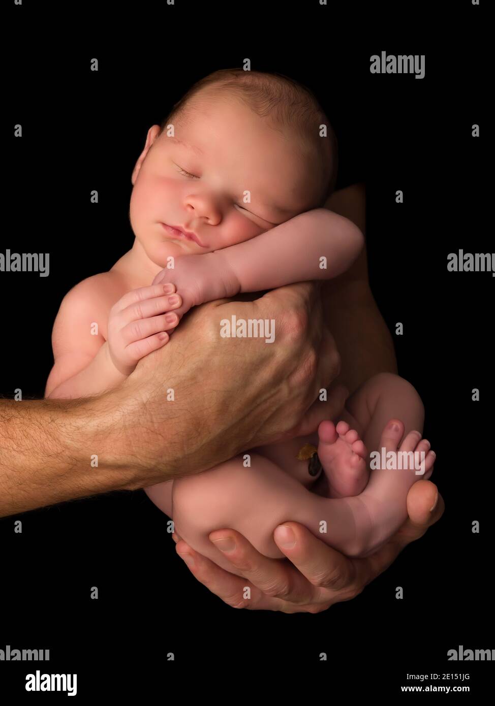Hände eines jungen Vaters, der seine 7 Tage alt hält Neugeborener Junge vor einem schwarzen Hintergrund Stockfoto