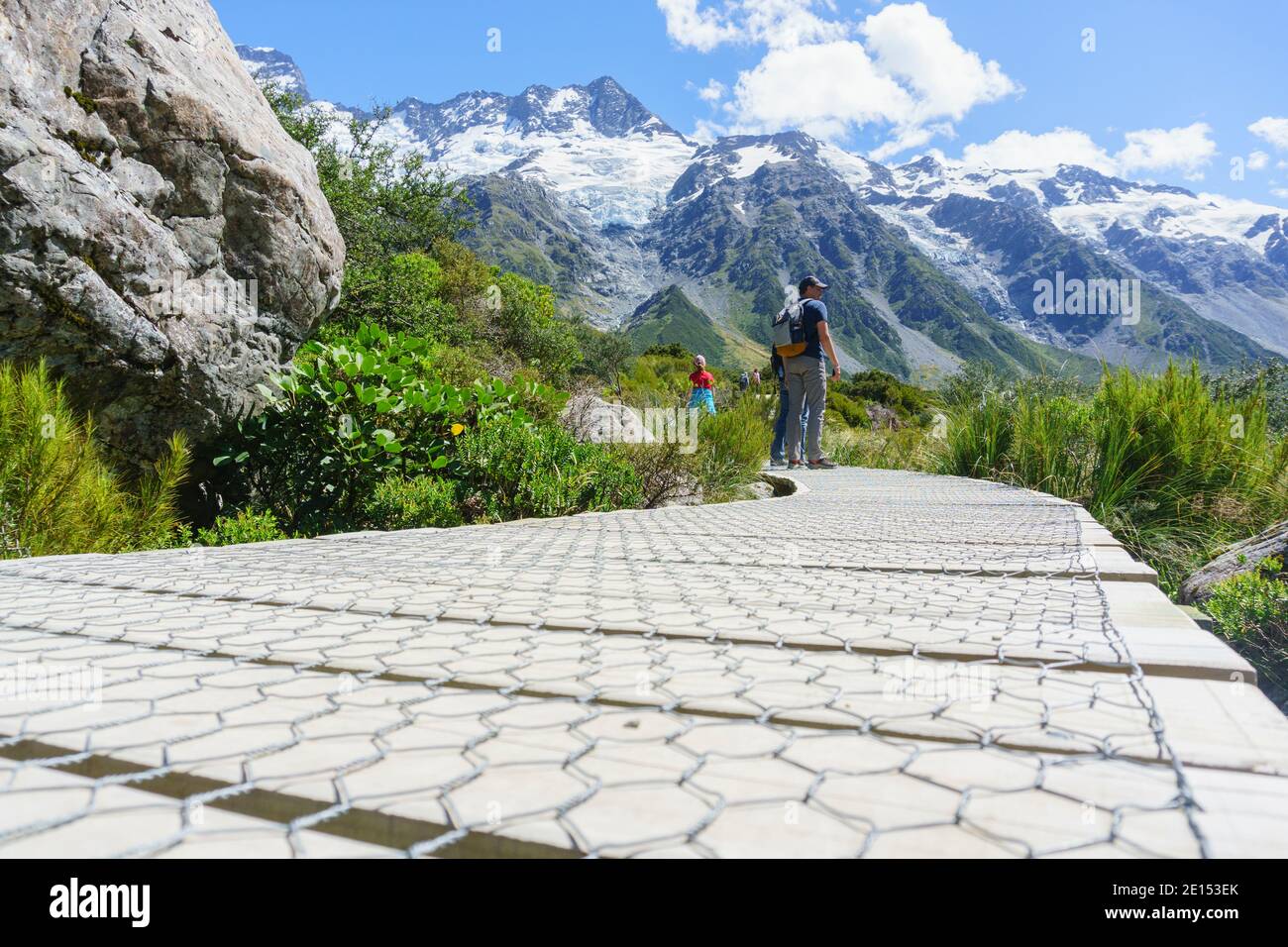 Mount Cook Neuseeland - Februar 16 2015; Touristen halten an, um den Blick auf den hölzernen Gehweg auf dem Hooker Valley Walk in South Island, Neuseeland, zu betrachten. Stockfoto