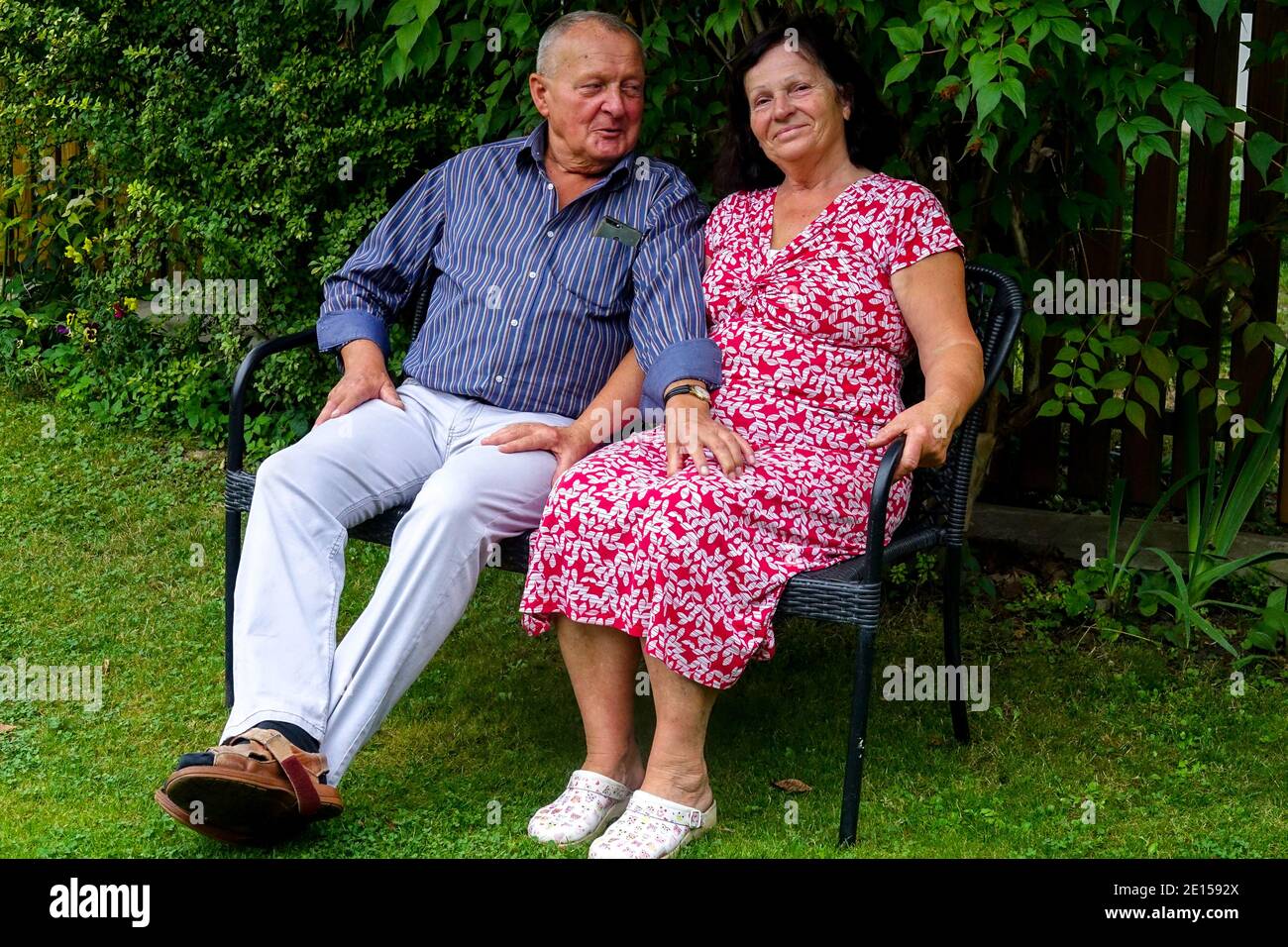 Seniorenbank, alter Mann und Frau sitzen auf einer Gartenbank, alte Leute auf einer Bank, Gartensitze Stockfoto