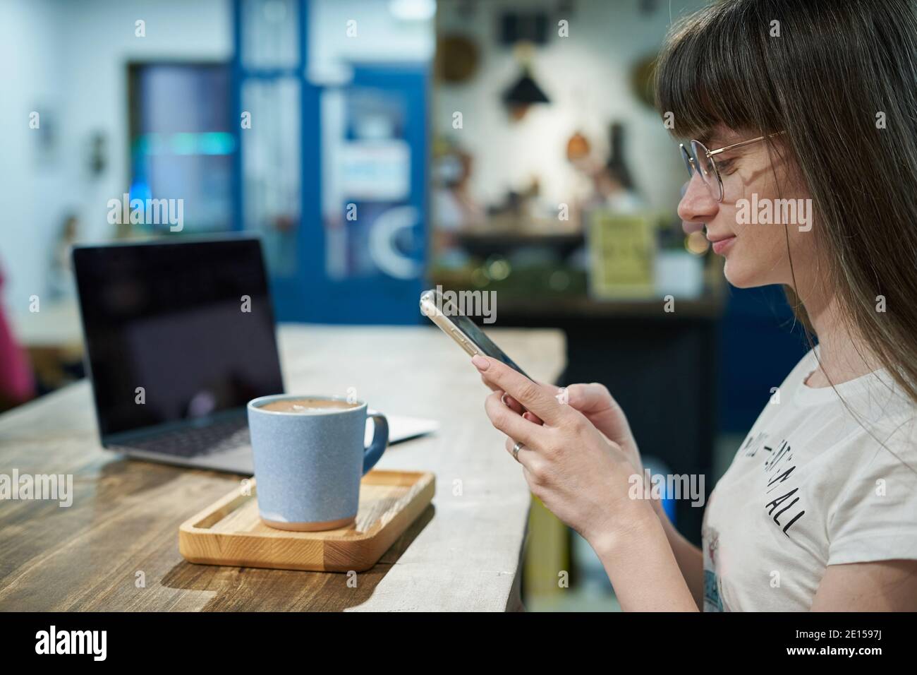 Junge Frau macht Fotos mit dem Smartphone von seinem Kaffee in Becher zum Bloggen Stockfoto