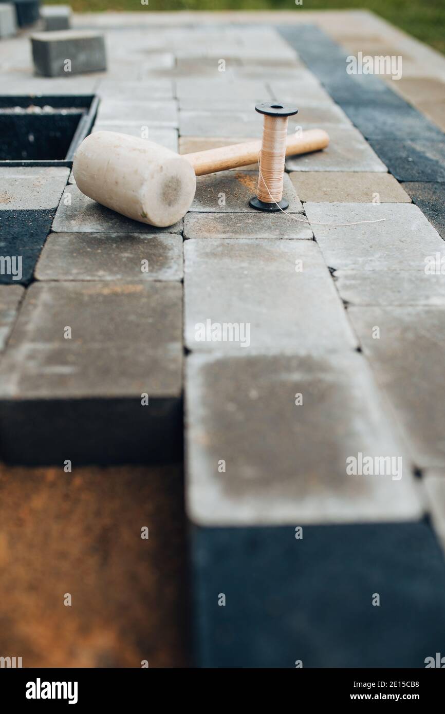 Werkzeuge zum Verlegen und Installieren von Pflasterplatten - Schnur Kelle Und Gummihammer Stockfoto