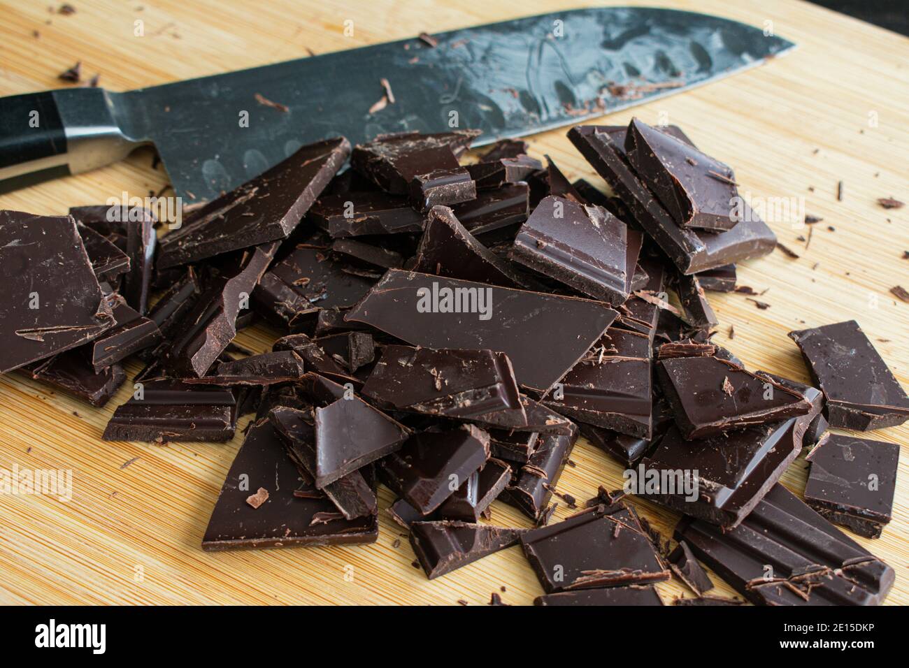 Schneidebrken von Backschokolade: Mit einem Küchenmesser zwei dunkle Schokoriegel in Stücke schneiden Stockfoto