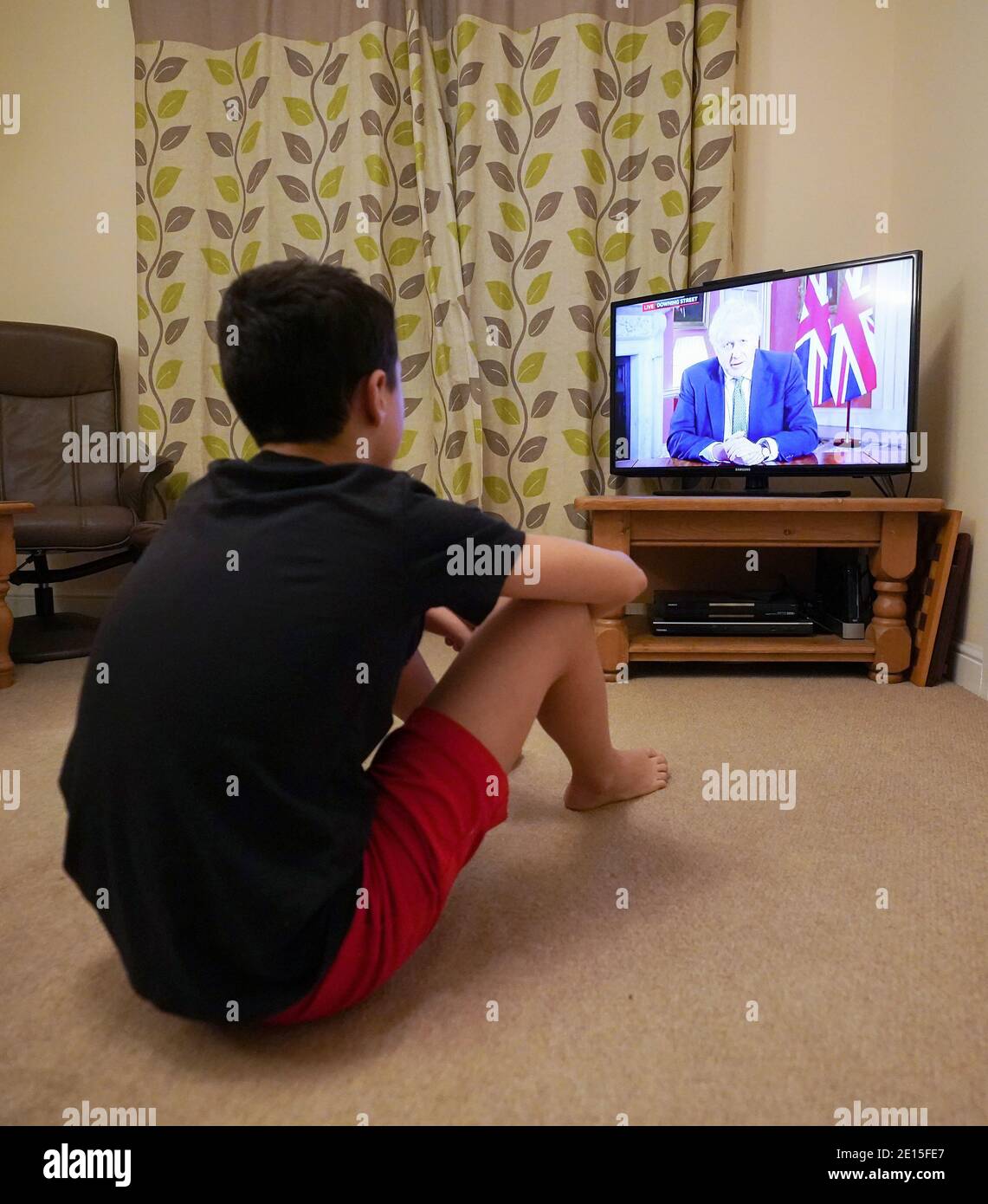 Ein Familienmitglied in Nottingham Frau beobachtet Premierminister Boris Johnson eine Fernsehansprache an die Nation von 10 Downing Street, London, die neue Notfallmaßnahmen zur Bekämpfung der Ausbreitung des Coronavirus in England. Stockfoto