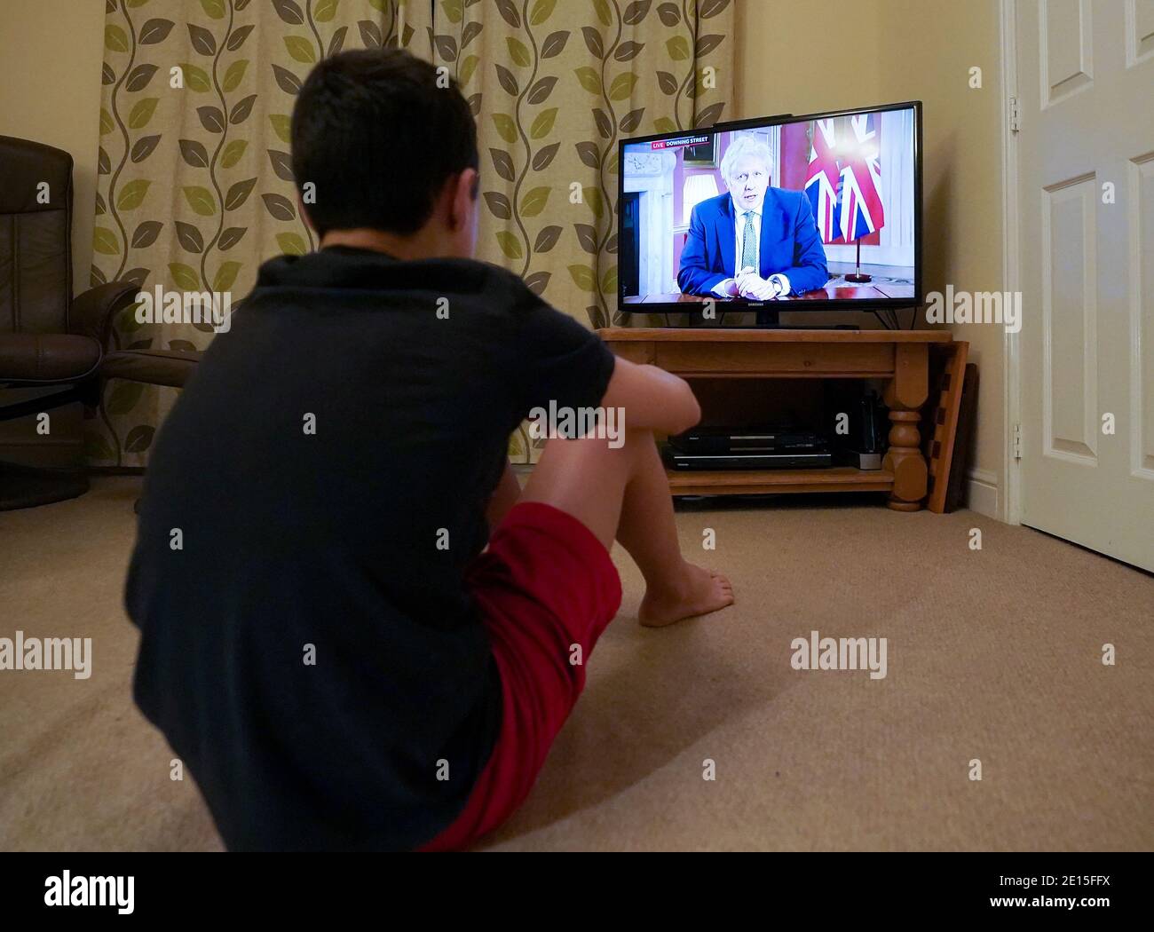 Ein Familienmitglied in Nottingham Frau beobachtet Premierminister Boris Johnson eine Fernsehansprache an die Nation von 10 Downing Street, London, die neue Notfallmaßnahmen zur Bekämpfung der Ausbreitung des Coronavirus in England. Stockfoto