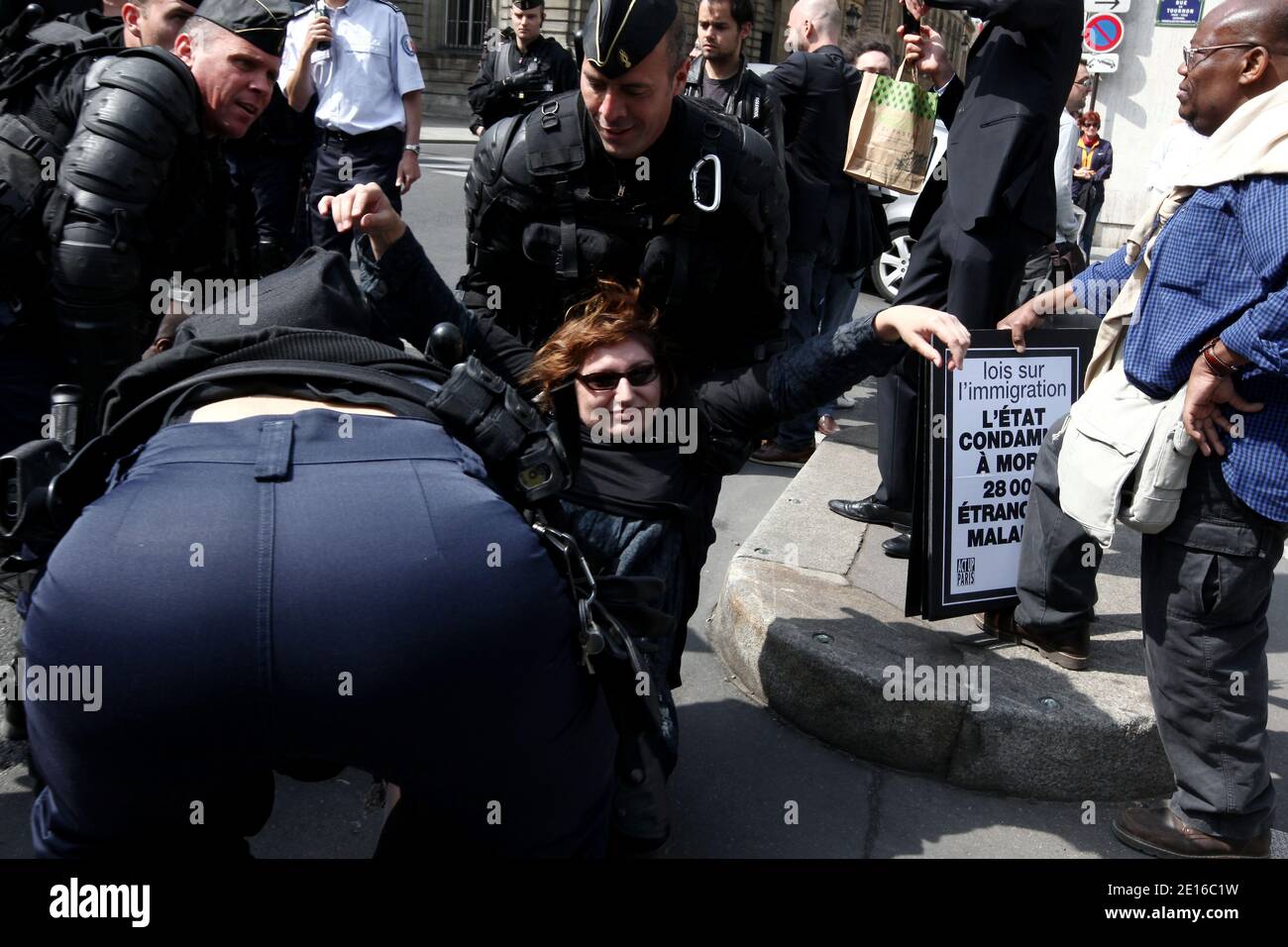 Non-Profit-Organisationen, die sich der Bekämpfung von HIV/AIDS-Hilfe widmen, und Act up-Aktivisten, die von französischen Anti-Riot-Polizisten umgeben sind, demonstrieren am 3. Mai 2011 vor dem französischen Senat in Paris. Gegen einen Gesetzesentwurf zu protestieren, der die Fähigkeit für schwer erkrankte Immigranten, vor allen Ausweisungsmaßes geschützt und im Rahmen des Aufenthaltsrechts für medizinische Versorgung stabilisiert zu werden, ändern wird. Die Plakate lauteten: "Strafe zum Tod von 28.000 kranken Einwanderern". Foto von Stephane Lemouton/ABACAPRESS.COM Stockfoto