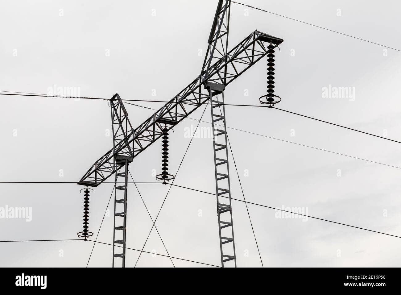 Hochspannungs-Poldetail isoliert am wolkigen Himmel. Stockfoto