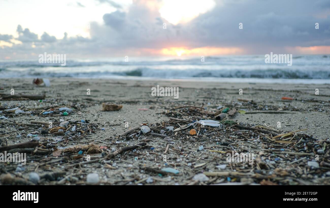 Mikroplastikpartikel Verschmutzung an schmutziger Küste, Sonnenuntergangszeit, Umweltabfall Bericht Stockfoto