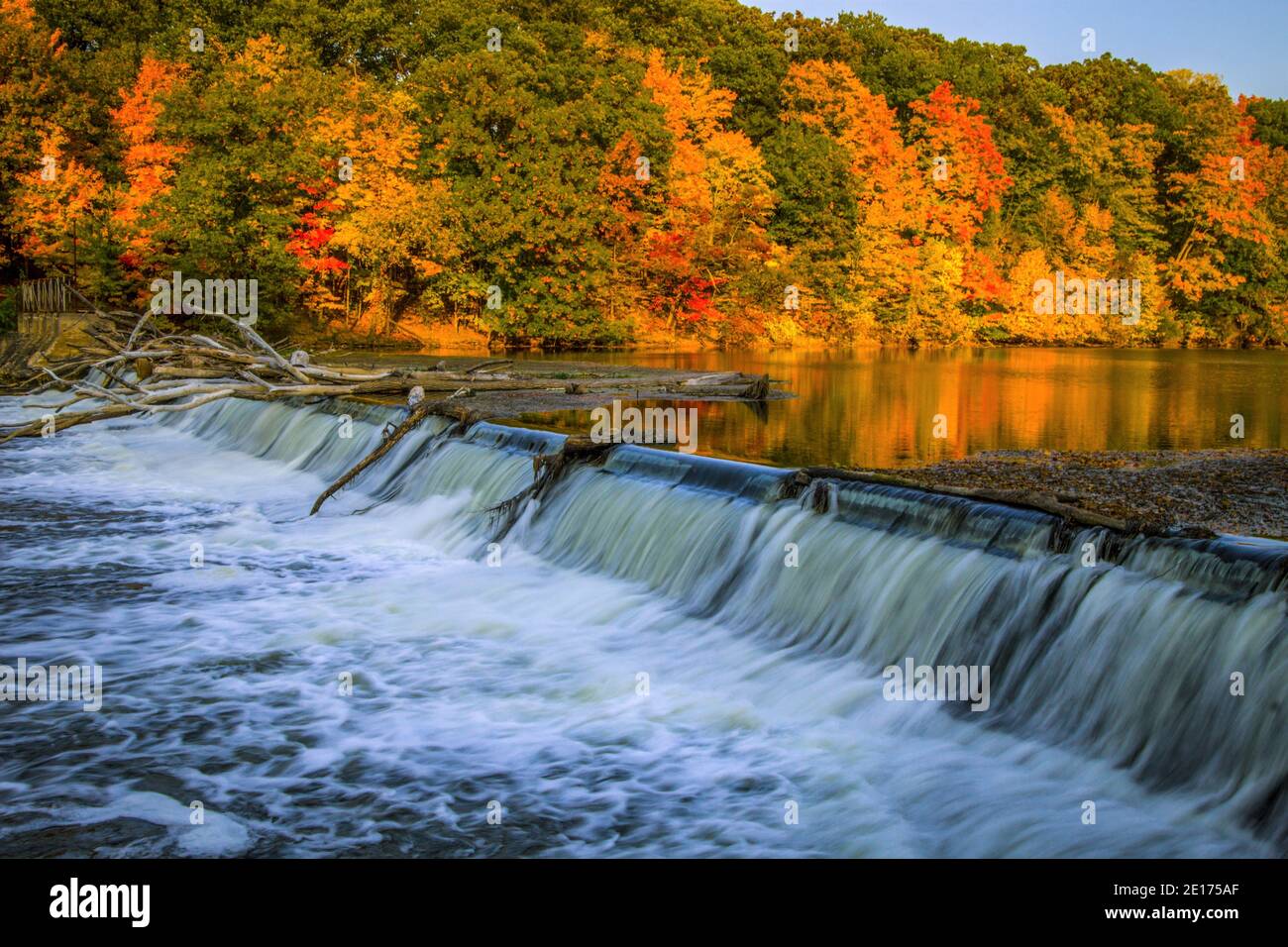 Flusslandschaft Des Herbstes. Wunderschöne Waldlandschaft mit spitzen Herbstfarben und einem kleinen Wasserfall im Fitzgerald County Park in Eaton County, Michigan. Stockfoto