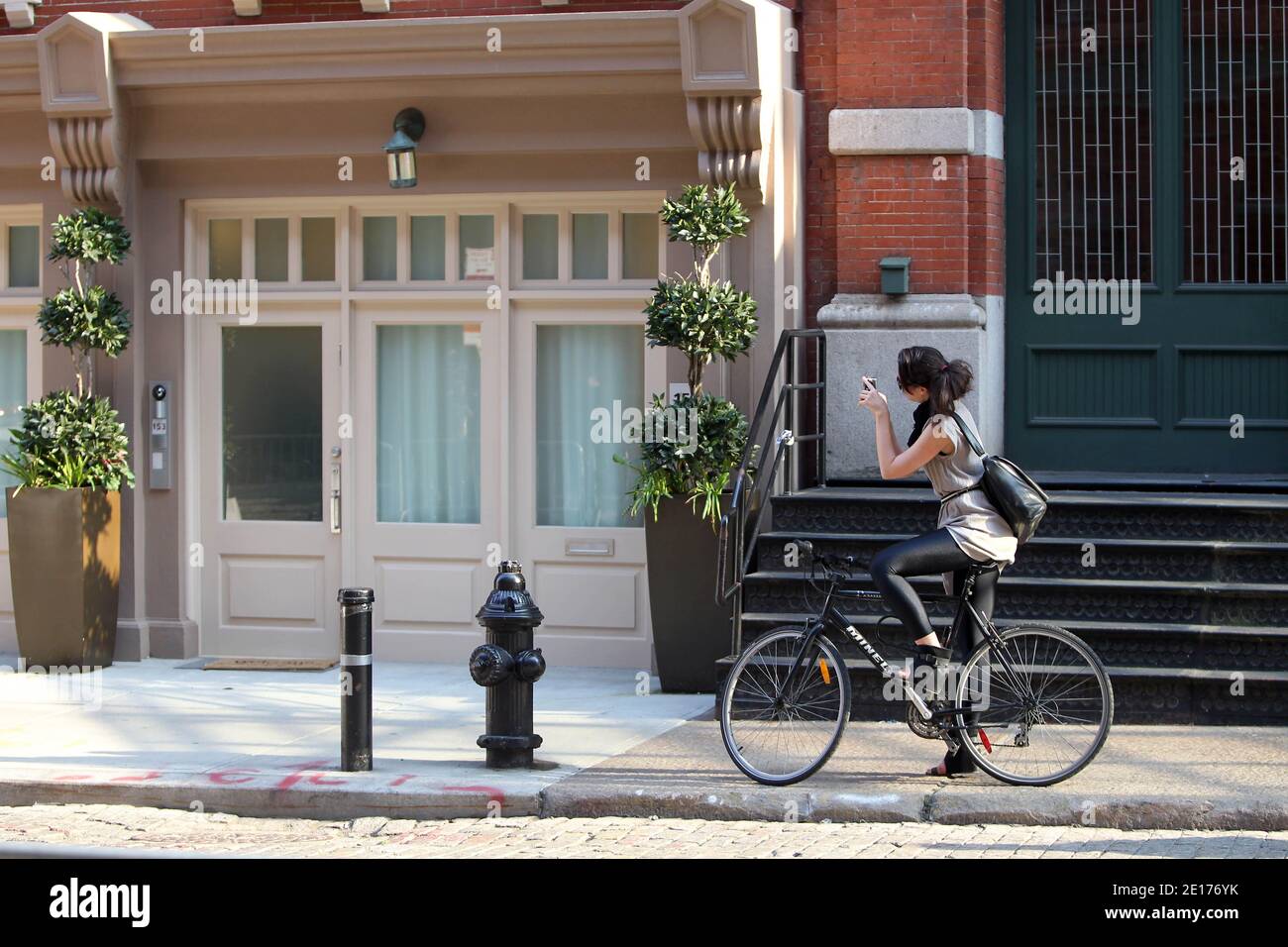 Frau auf dem Fahrrad fotografiert das Stadthaus in der Tribeca-Gegend von Manhattan, wo der ehemalige IWF-Chef Dominique Strauss-Kahn am 26. Mai 2011 in New York, NY, unter Hausarrest gestellt wird.Foto: Guerin-Taamallah-Pantaleo/ABACAPRESS.COM Stockfoto